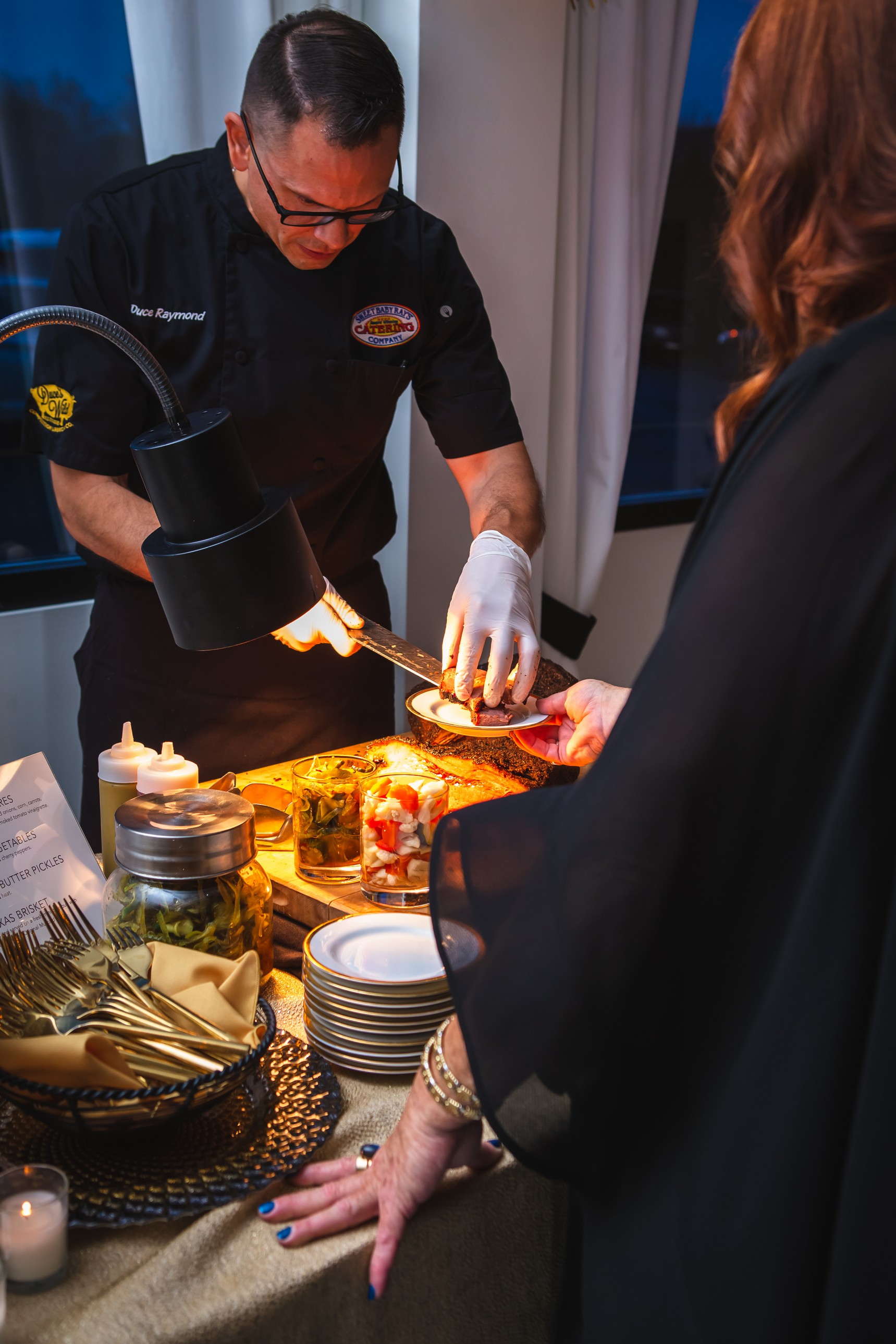 Duce Raymond serving barbecue at a live catering activation